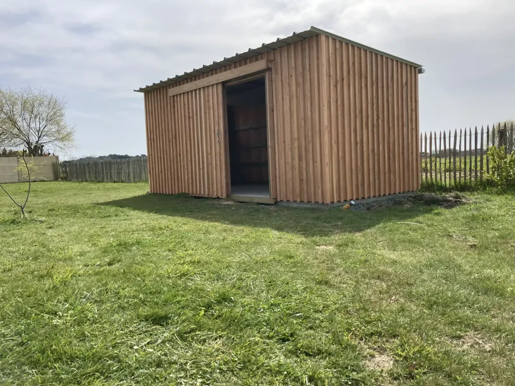 Un abri de jardin sur mesure avec porte coulissante et bardage marin vertical