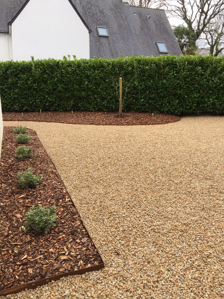 allée en gravillons roulés vanille avec des massifs bordures corten autour