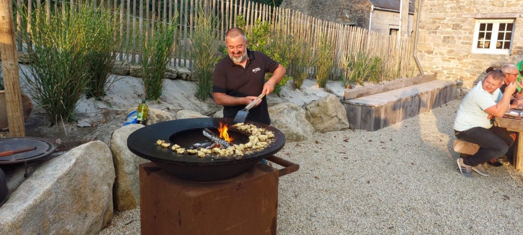 Christophe, salarié Kerne Elagage, nous prépare des morceaux de poulet, précédemment marinés, sur le brasero OFYR lors d'une soirée entreprise.