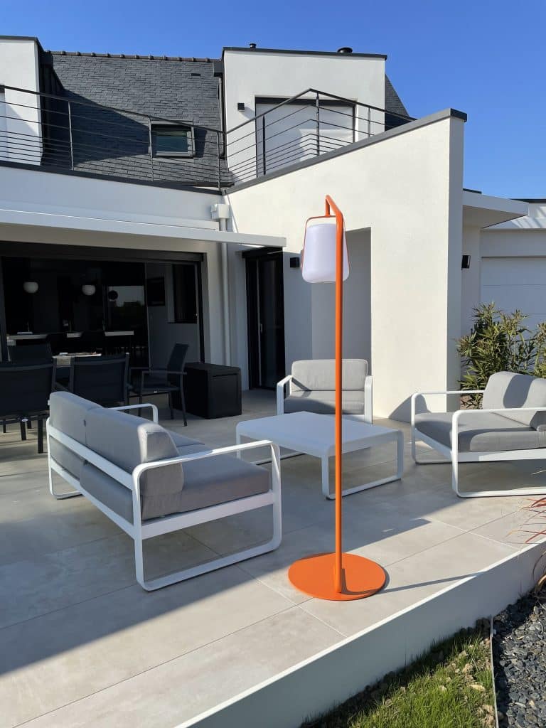 Saloon de jardin fermob sur une terrasse gres ceram devant maison